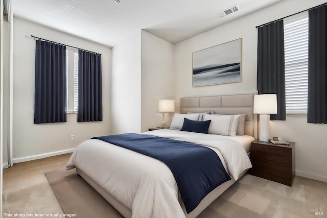 carpeted bedroom with baseboards and visible vents