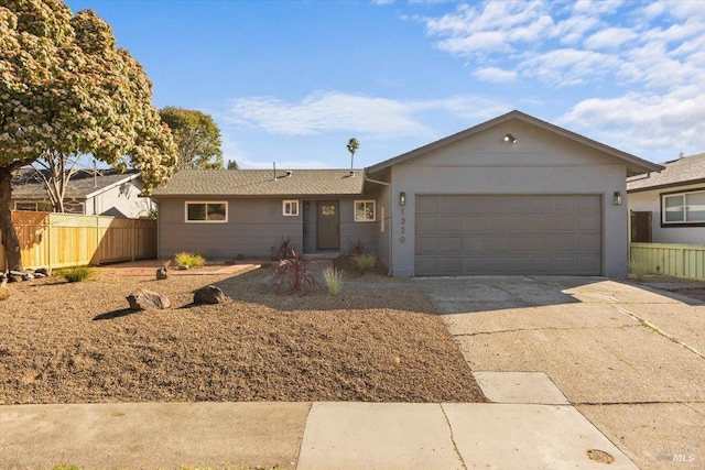 single story home featuring an attached garage, fence, and concrete driveway