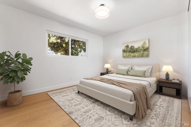 bedroom featuring baseboards and light wood finished floors