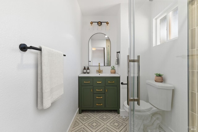 bathroom with toilet, a shower with shower door, vanity, tile patterned flooring, and baseboards