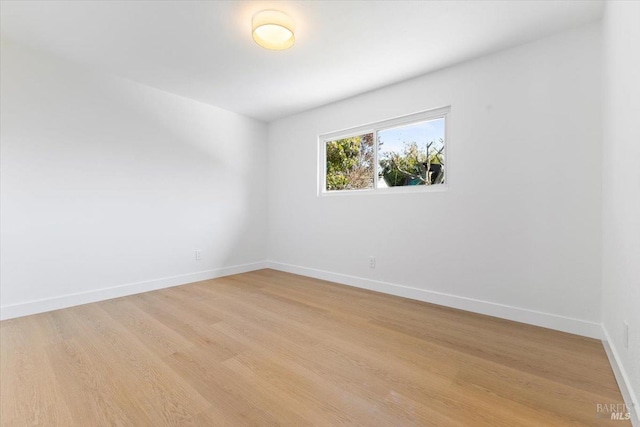 unfurnished room featuring light wood-type flooring and baseboards