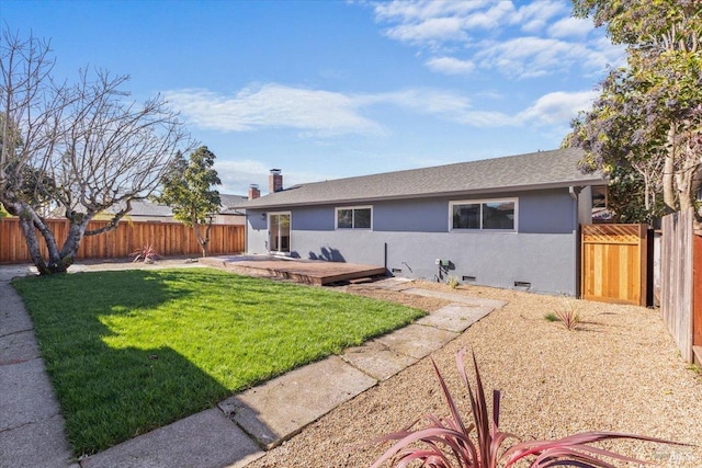 rear view of property with a chimney, stucco siding, a lawn, crawl space, and a fenced backyard