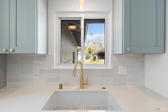 interior details featuring tasteful backsplash, light countertops, and a sink