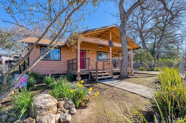 view of front of home featuring fence and a ceiling fan