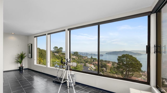 sunroom / solarium featuring a water view