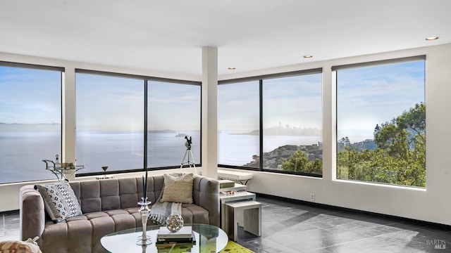 sunroom featuring a water view