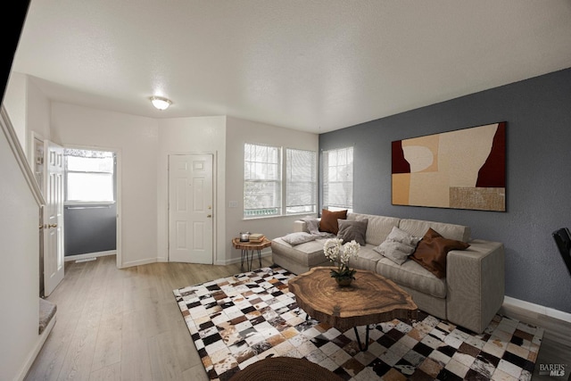 living area with light wood-style floors and baseboards