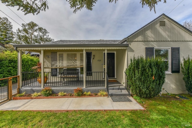 single story home featuring a porch and a front lawn