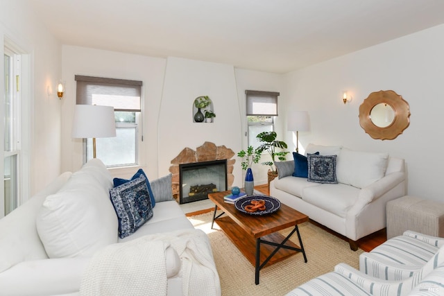 living room with a fireplace, plenty of natural light, and wood finished floors