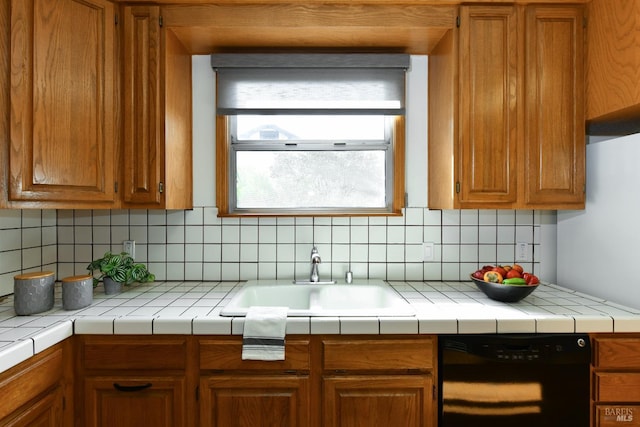 kitchen with dishwasher, brown cabinetry, a sink, and backsplash