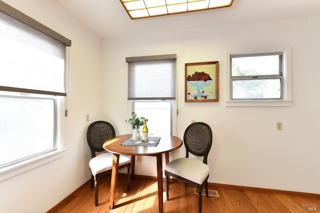 dining area with light wood-style flooring, visible vents, and baseboards