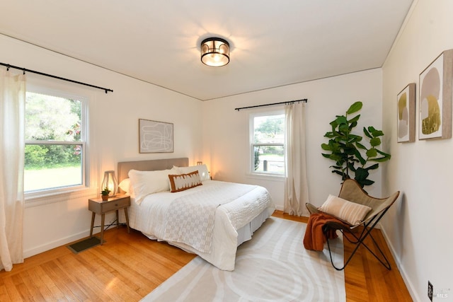 bedroom featuring multiple windows, visible vents, and light wood-style floors