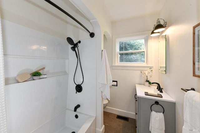 bathroom with visible vents, toilet, vanity, shower / tub combination, and baseboards