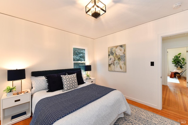 bedroom with baseboards and wood finished floors