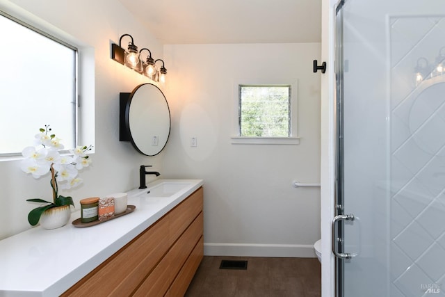 bathroom with a stall shower, visible vents, baseboards, and vanity