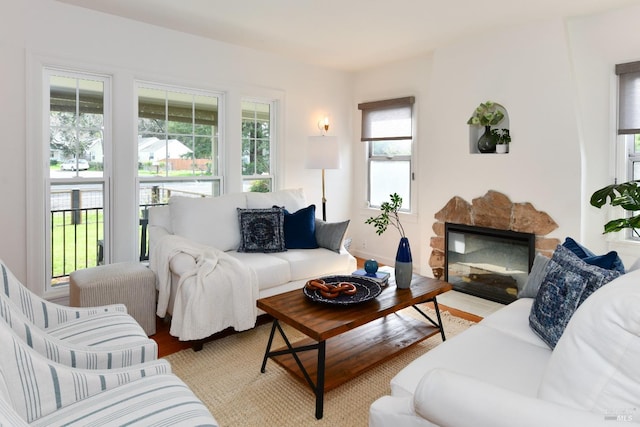 living area featuring a stone fireplace and wood finished floors