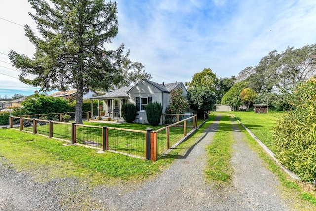 bungalow with driveway, a fenced front yard, a gate, and a front yard