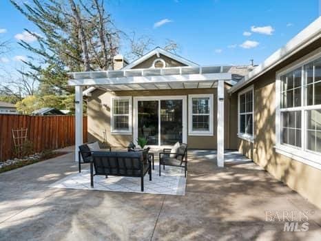 view of patio featuring an outdoor hangout area, fence, and a pergola