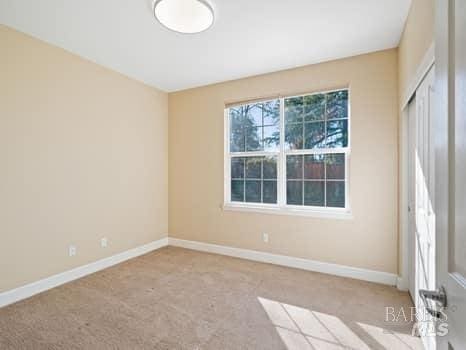 carpeted spare room featuring baseboards