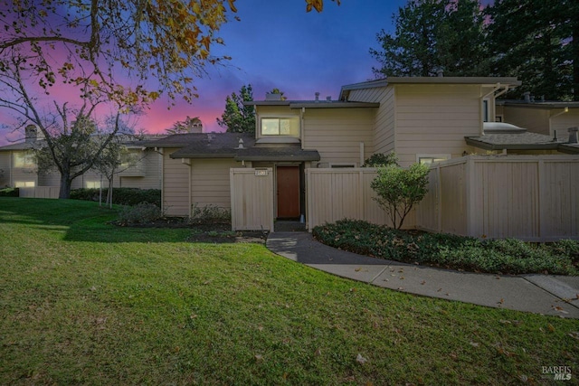 mid-century inspired home with a yard and fence