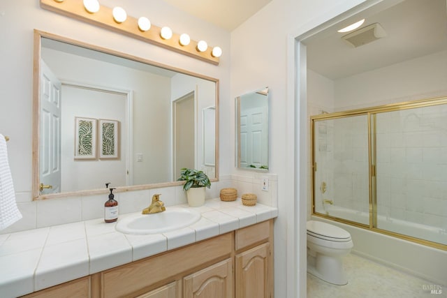 full bath with combined bath / shower with glass door, vanity, and toilet