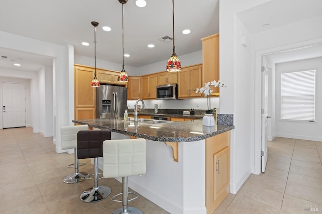 kitchen featuring recessed lighting, visible vents, appliances with stainless steel finishes, a sink, and a kitchen breakfast bar