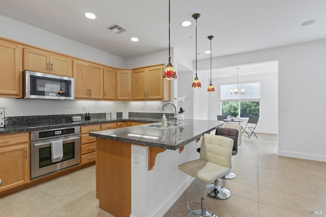 kitchen featuring recessed lighting, a sink, visible vents, a kitchen breakfast bar, and appliances with stainless steel finishes