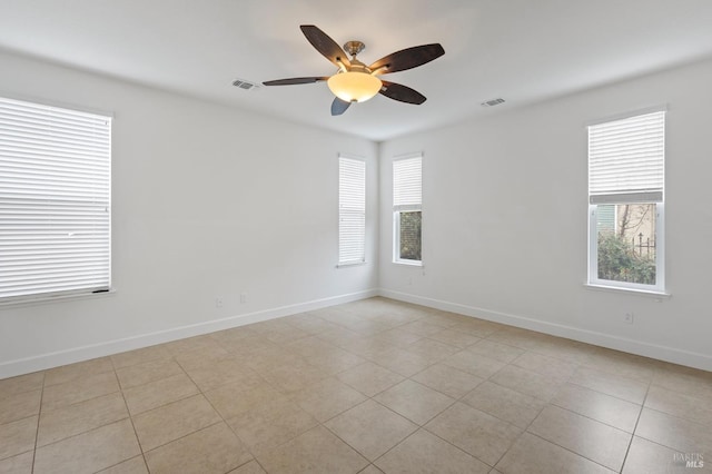 unfurnished room featuring a healthy amount of sunlight, baseboards, and visible vents