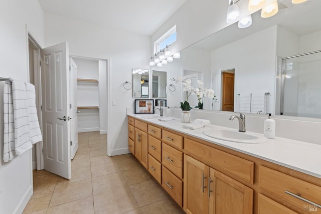 full bathroom featuring double vanity, an enclosed shower, a sink, and tile patterned floors