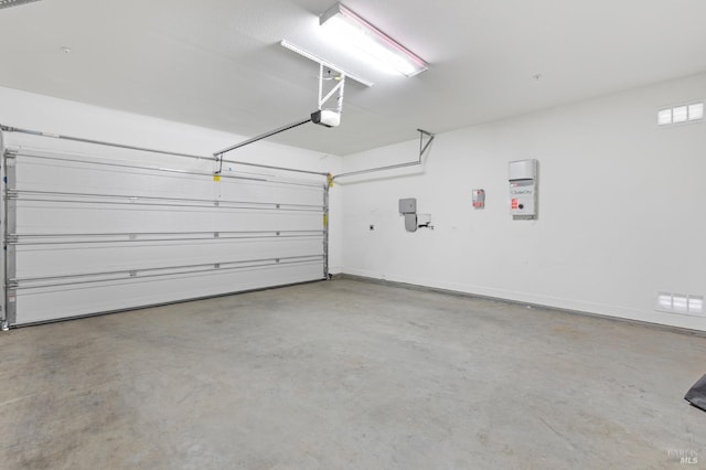 garage with baseboards and a garage door opener