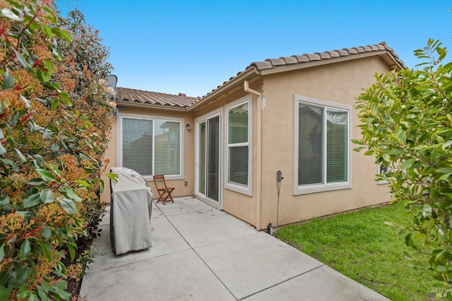 exterior space featuring a patio, a tiled roof, and stucco siding