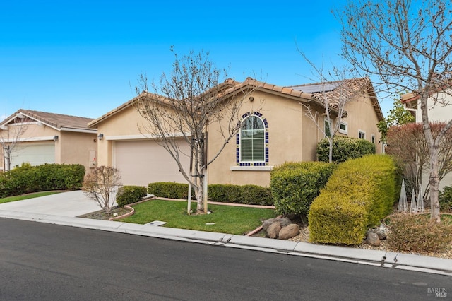 view of front of property with concrete driveway, an attached garage, a tiled roof, and stucco siding