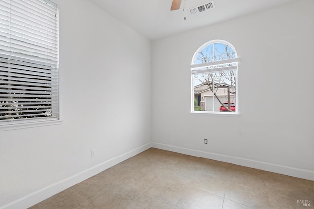 spare room featuring light tile patterned floors, ceiling fan, visible vents, and baseboards