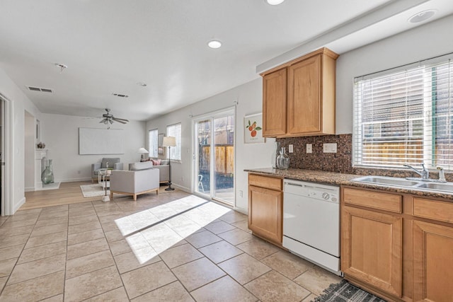 kitchen featuring tasteful backsplash, visible vents, open floor plan, white dishwasher, and a sink