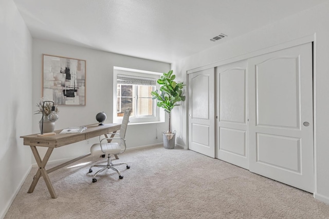 carpeted office space with visible vents and baseboards