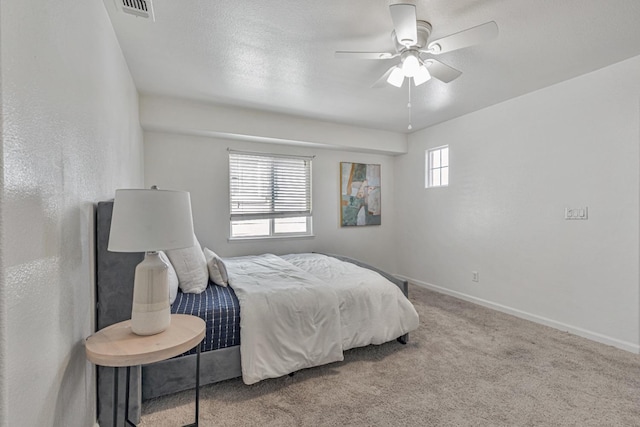 carpeted bedroom featuring visible vents, baseboards, and a ceiling fan