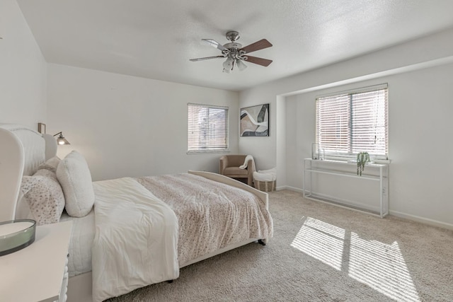 bedroom featuring a textured ceiling, carpet flooring, baseboards, and ceiling fan