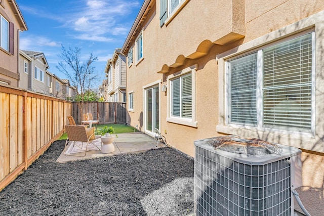 view of yard featuring a residential view, central AC, a fenced backyard, and a patio area