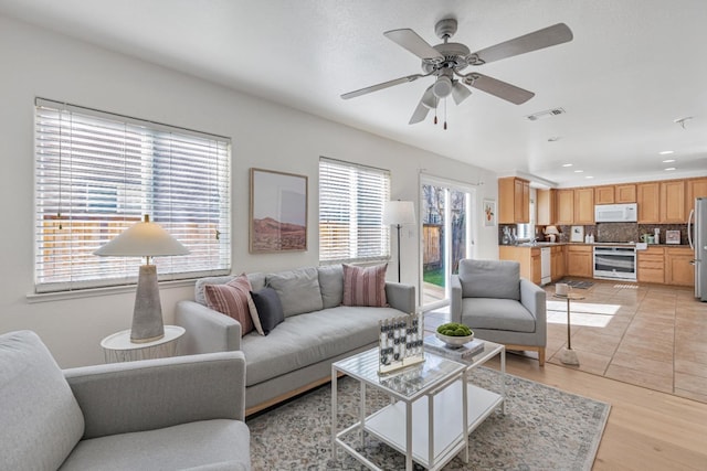 living room with light wood-style flooring, recessed lighting, a ceiling fan, and visible vents