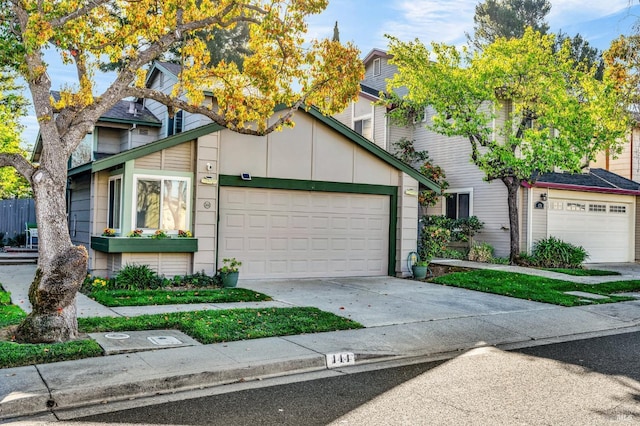 view of property featuring concrete driveway and an attached garage