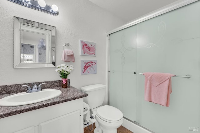 full bathroom with a shower stall, toilet, and vanity