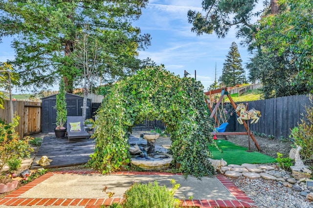 view of yard with a storage shed, a playground, an outbuilding, and a fenced backyard