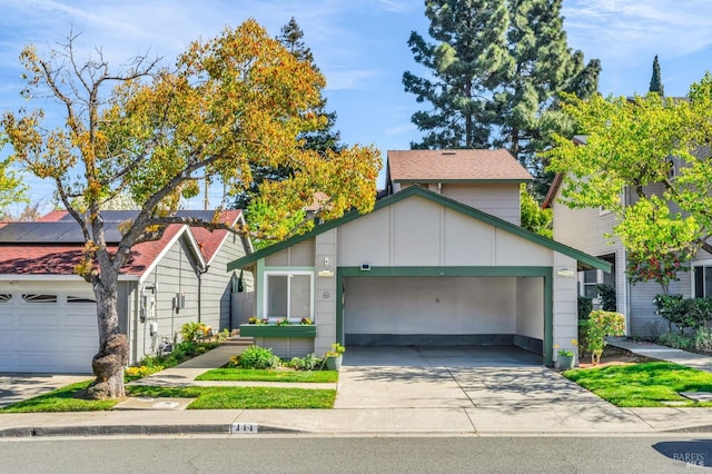 view of front of home featuring a garage, solar panels, and concrete driveway