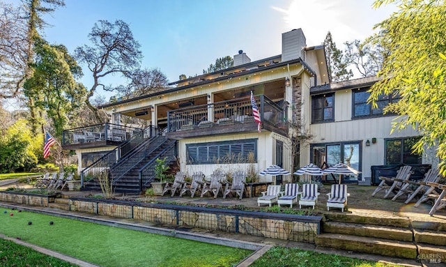 rear view of property with a patio, a chimney, a balcony, and stairs