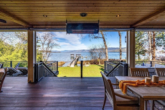 wooden deck with a lawn and a water and mountain view