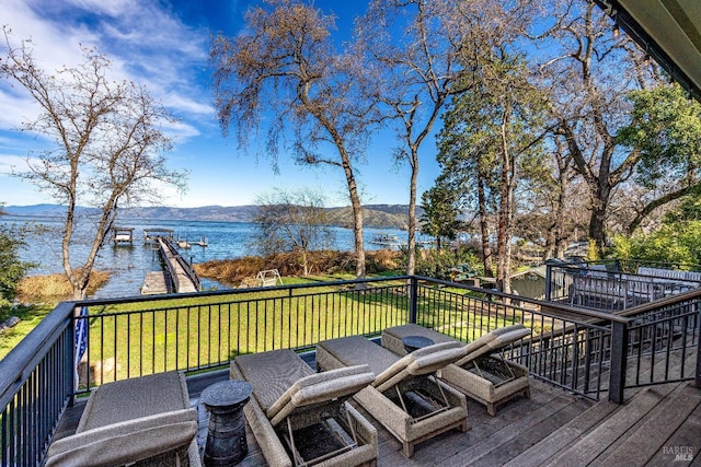 wooden terrace featuring a yard and a water and mountain view