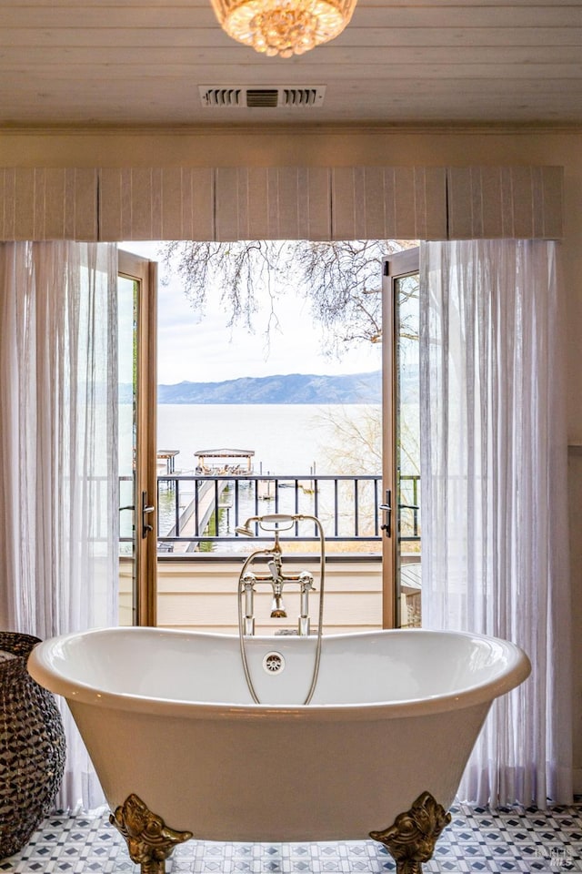 full bathroom featuring a freestanding bath, visible vents, and tile patterned floors