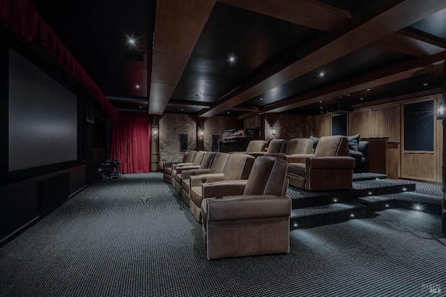 carpeted cinema featuring wood walls and beam ceiling