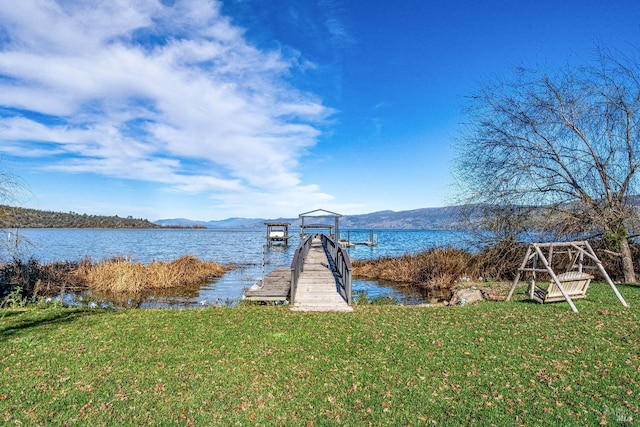 dock area featuring a yard and a water and mountain view