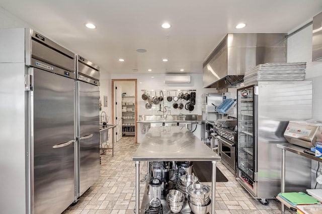 kitchen with recessed lighting, stainless steel countertops, wall chimney range hood, and high quality appliances